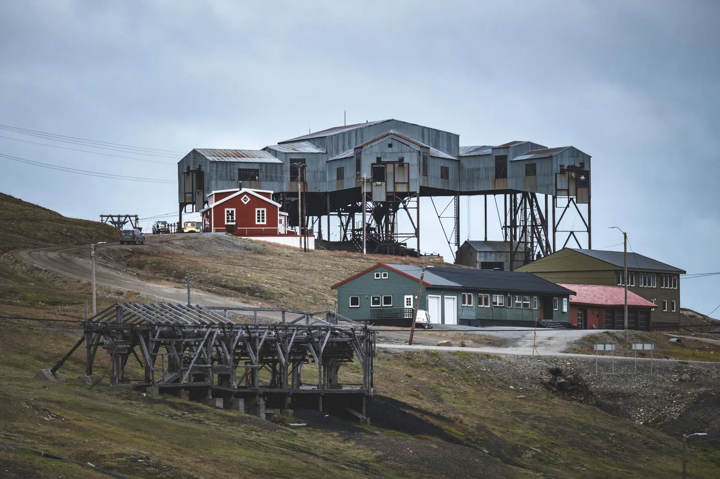 Old coal cableway central station on stilts above houses, wooden cableway trestle in front